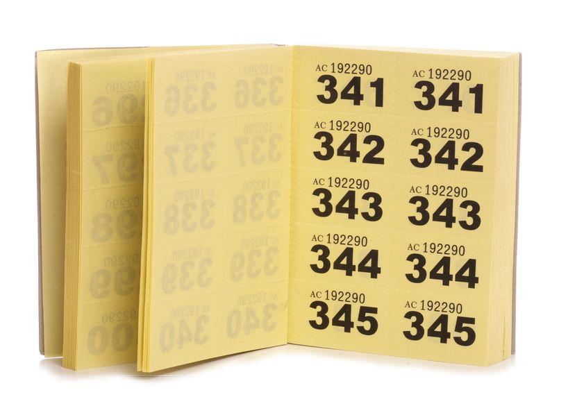 Book of yellow cloakroom tickets, opened to reveal the contents