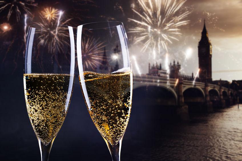 Celebrating New Year's Eve in the city - toasting with champagne glasses in front of Big Ben